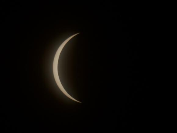 A close-up photo of the 2024 total solar eclipse, taken by Christopher Masi, Professor of Chemical and Physical Sciences. The photo is completely dark besides a sliver of the sun. The sun is almost completely obstructed by the moon, making it look like a crescent.