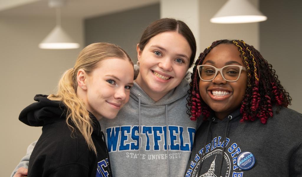 Three students smiling wearing Westfield State sweatshirts.