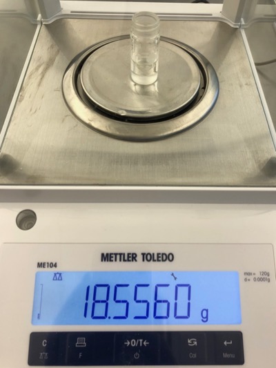 a photograph of a 3-mL vial containing the t-pentyl chloride product. The mass of the combination reads as 18.5560 g