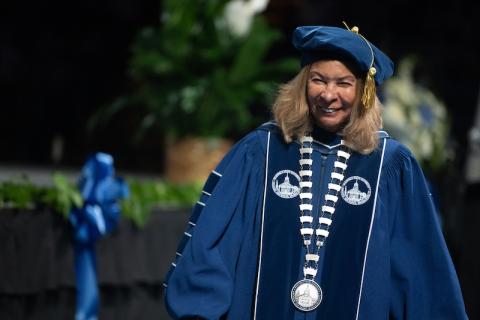 President Linda Thompson at the Undergraduate Commencement Ceremony. She is dressed in blue robes and a blue cap.