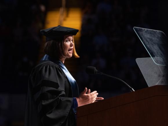 Mary Louise McDonald, President of Ireland’s Sinn Féin party and leader of Teachta Dála for Dublin Central speaking at the 2024 Commencement Ceremony. She wears a black robe and cap and is at a podium.