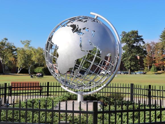 Campus globe with blue skies behind it.