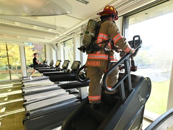 Sam Lemanski, a firefighter for South Hadley and Westfield State’s Director of Emergency Management, climbing the stair master in remembrance of 9/11 in full firefighter gear.