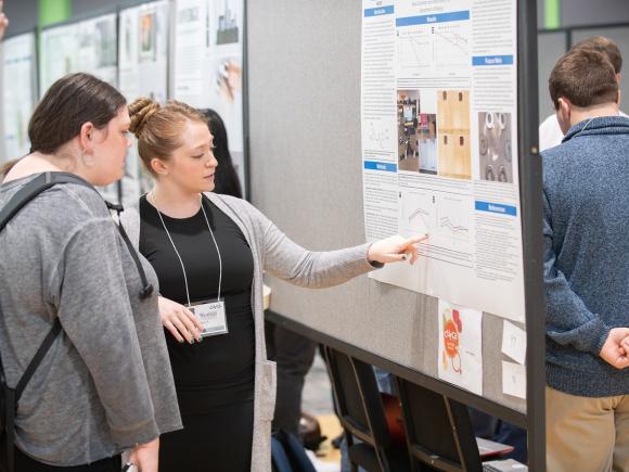 Biology student presenting research at CURCA undergraduate research event.