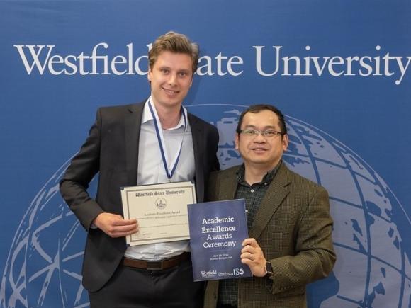 Finance student smiling with faculty member at Academic Excellence Award Ceremony. 