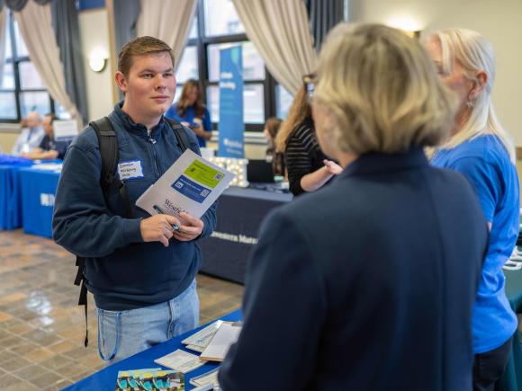 people talk at a table career fair