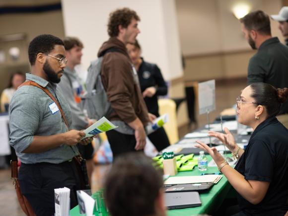Student networking with an employer during a campus career fair at Westfield State University.