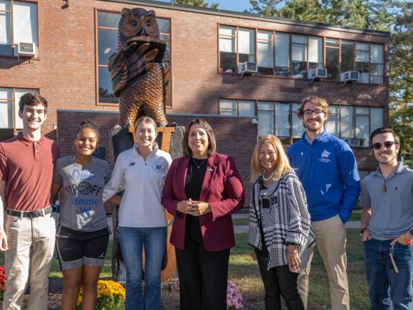 Group stands in front of Owl statue