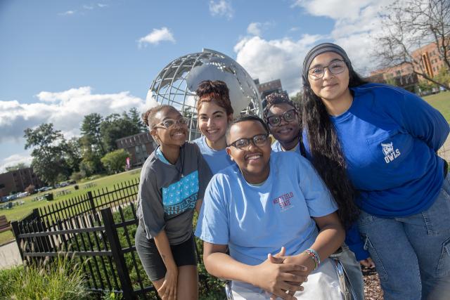 Photo of five TRIO students by campus globe smiling
