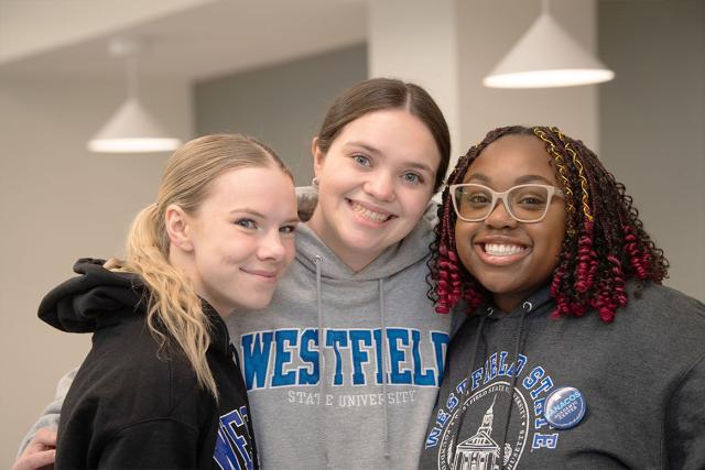 Three social work majors at Westfield State University smile while posing for a photo.