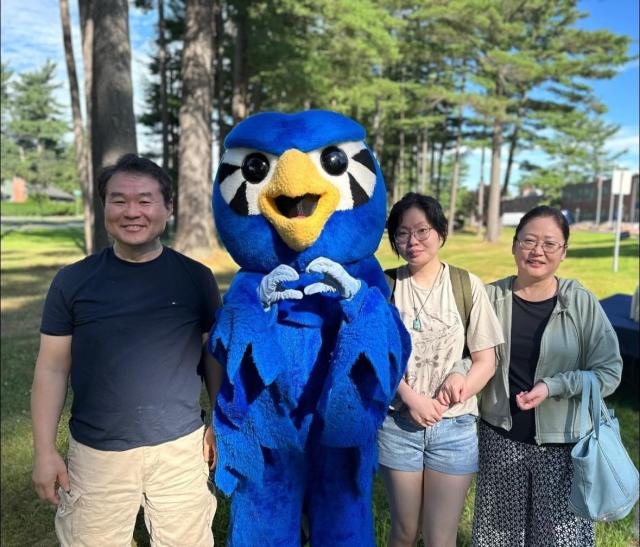 A family smiling with Nestor at New Student Orientation.