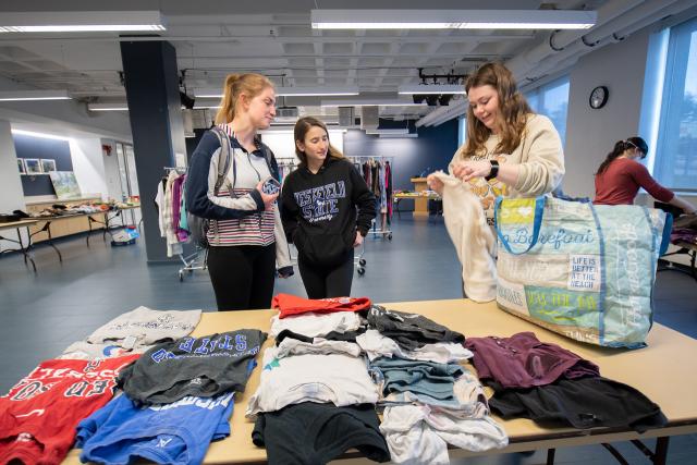 University thrift store with three students chatting.