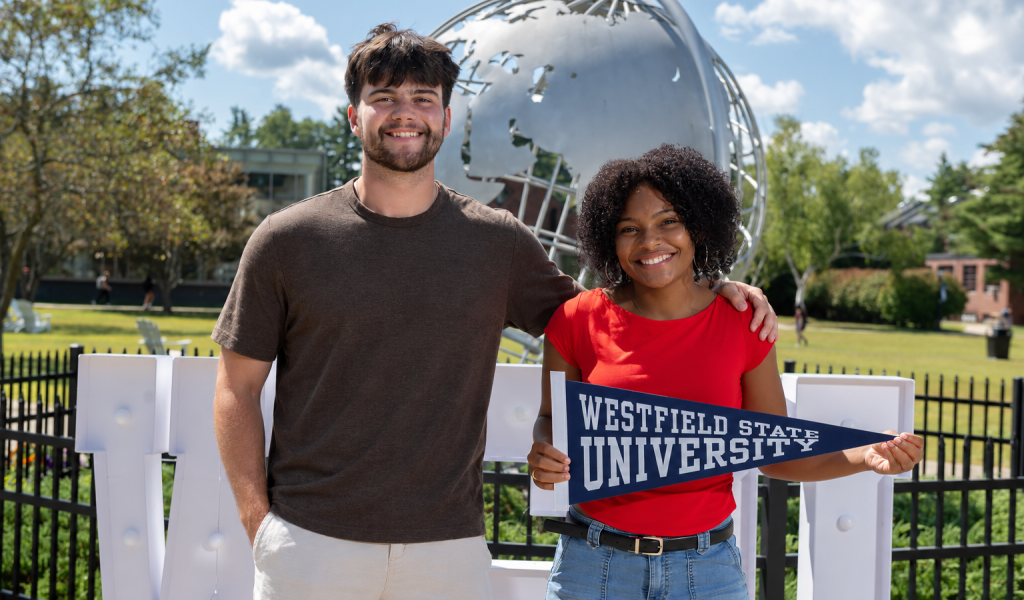 Two students standing at the campus globe on the first day of the fall semester.