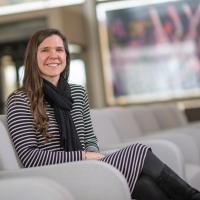 Bethany Mather, a teacher at Farmington River Regional School and alumna of Westfield State University, was recently named this year’s Massachusetts University Educator Alumni Award recipient. She's sitting in the lobby at Horace Mann, in a gray chair. An unfocused window is behind her.